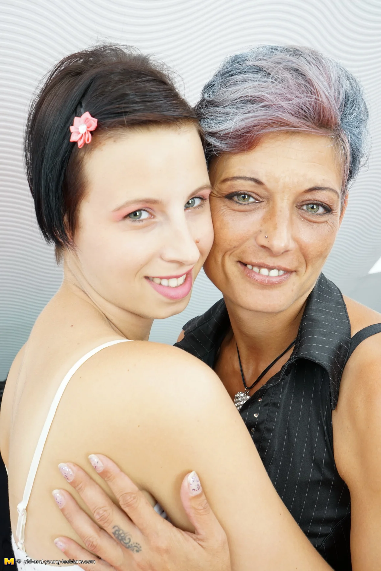 Old and young lesbian couple make out on the couch